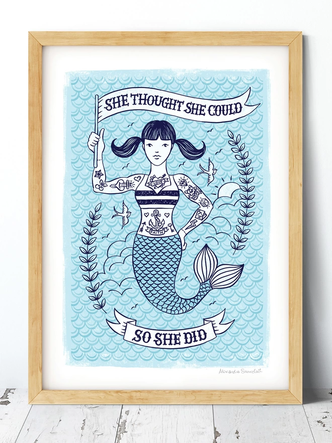 blue tattoed mermaid encouragement print in wood frame with white wash floor