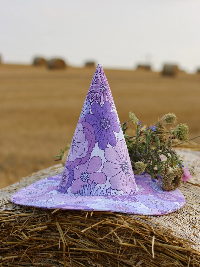 A purple witch hat perfect for a halloween costume in a field