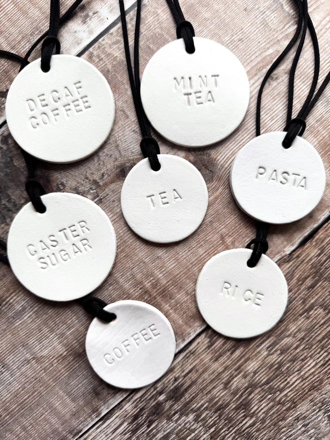 Minimalist white leather pantry tags with hand-stamped labels for kitchen storage. Rustic and stylish labels with black cord, ideal for home organisation and pantry décor.