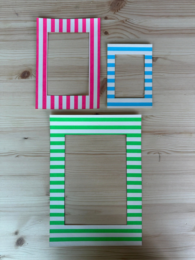 Thin Striped Screen Printed A6 / A5 / A4 Photo Mount. green pink and blue versions of striped mount pictured on wooden surface.
