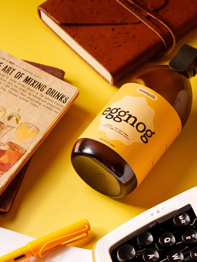 Eggnog bottle surrounded by a fountain pen and a journal