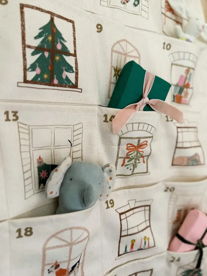 Fabric Christmas House Advent Calendar, close up, there is a toy elephant in the pocket.