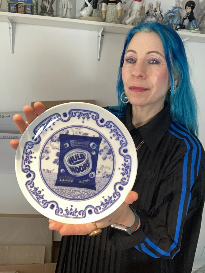 Blue and white Delft style decorative plate featuring a packet of Hula Hoops crisps in the centre.
