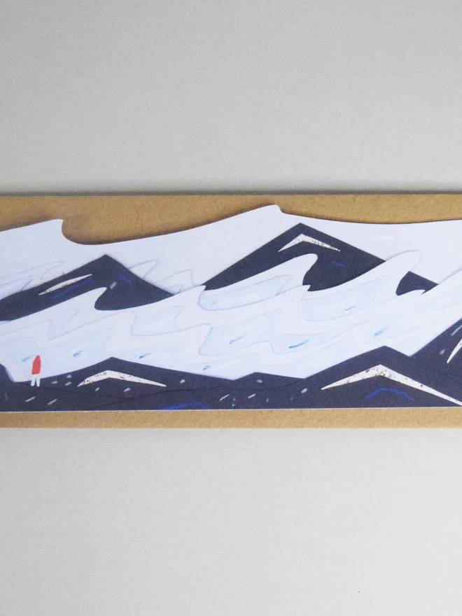 A cut out card of a stormy seascape on top of an envelope