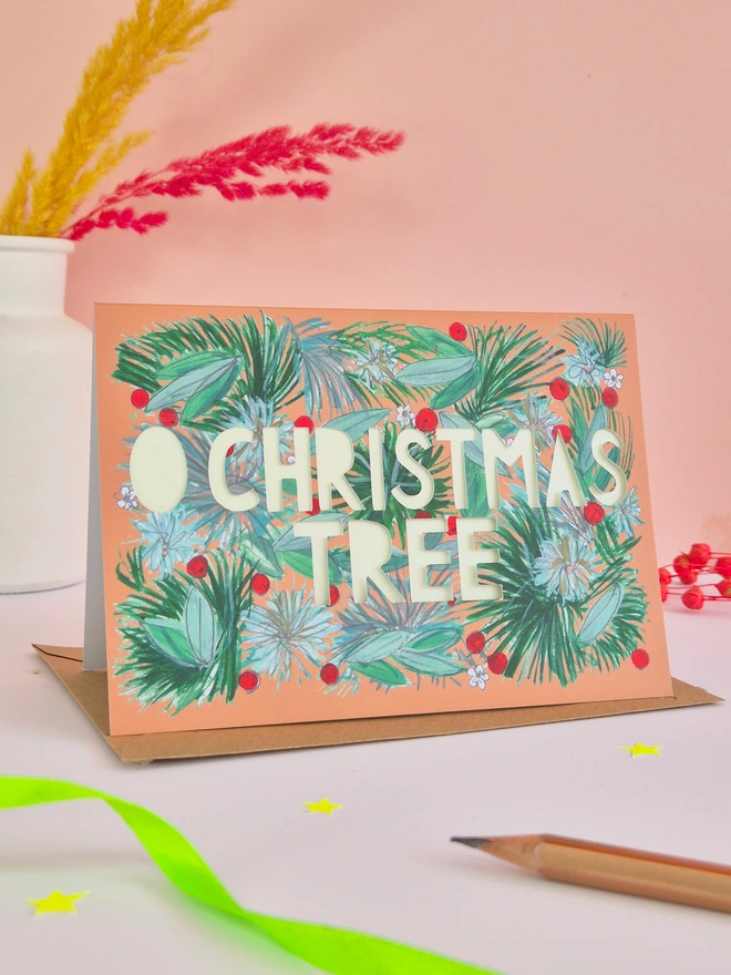 Holly berry and pine branch illustration card with O Christmas Tree paper cut text, backed with pearlescent green paper