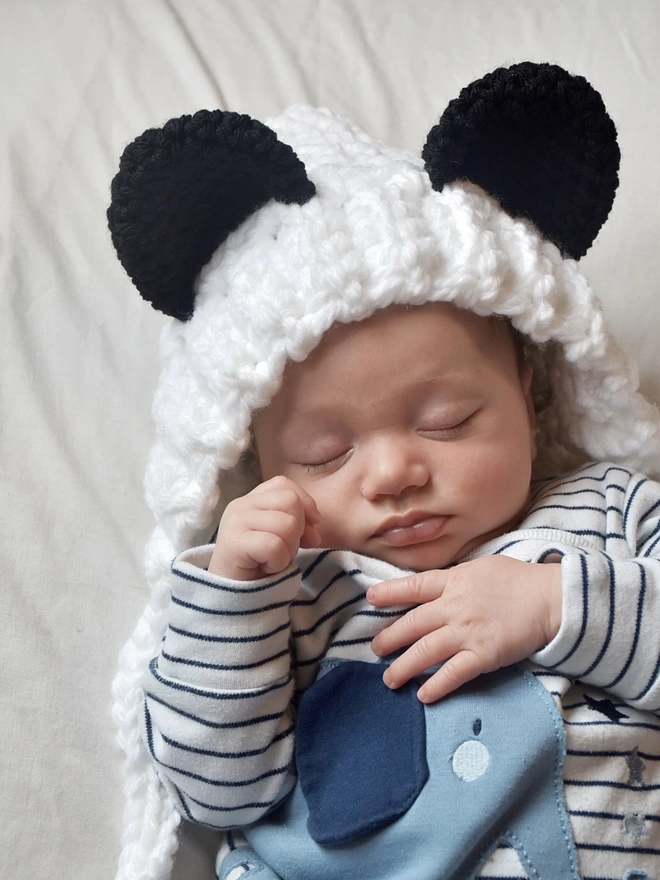 Baby wearing crocheted Panda bonnet