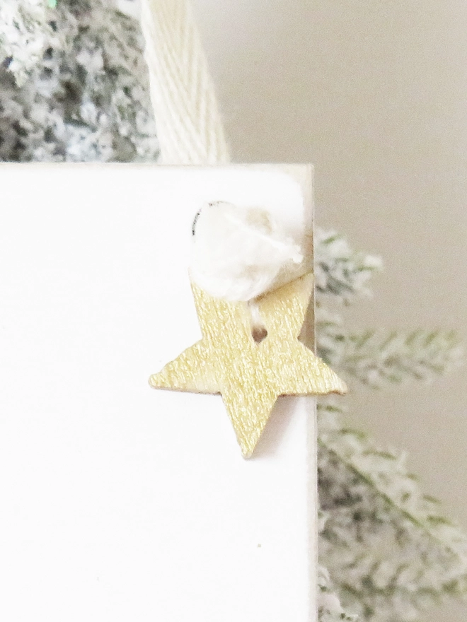 painted white banner with North Pole message strung with cotton and decorated with a wooden gold star.