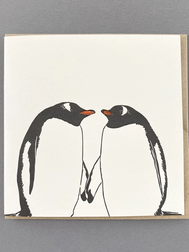 Full image of two Gentoo penguins holding flippers and ready to kiss 