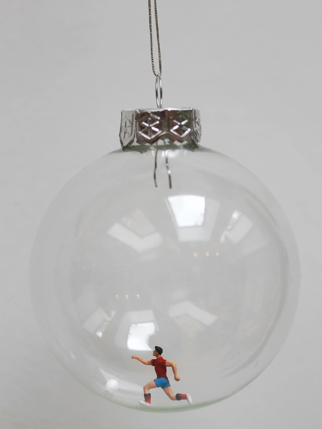 Miniature figure of a soccer player in a glass Christmas bauble 