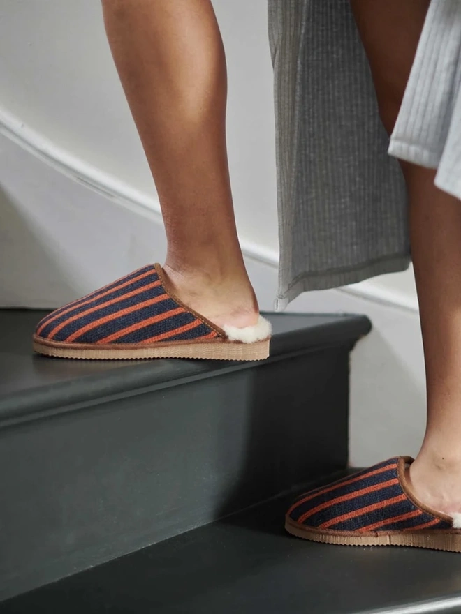 Women's Lambswool & Sheepskin Slippers, a person wearing a pair of colourful slippers indoors. 