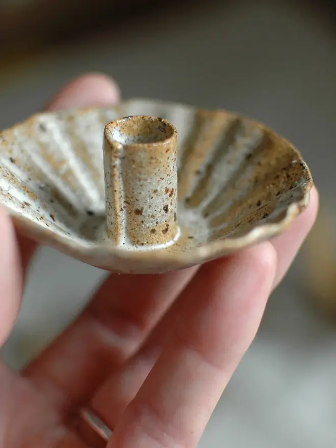 Handmade Natural Speckled Ceramic Candlestick Holder, a person holding a ceramic candlestick holder in the air. 