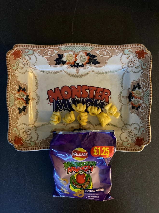 Vintage decorative 'Monster Munch' plate with real Monster Munch crisps scattered on the plate.