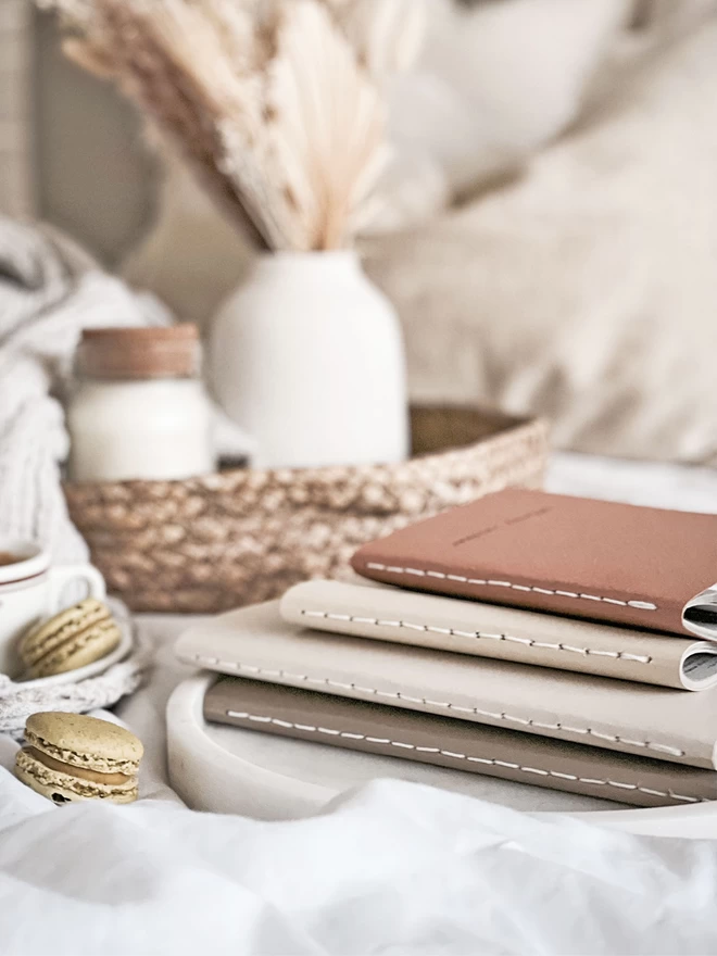 stack of journals in a selection of neutral colours with their stitched spines facing forward