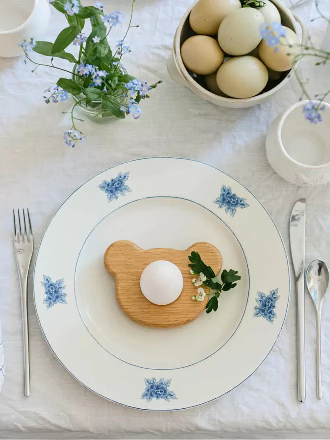 Wooden Egg Cup Bear birds eye view of egg cup on a white plate with blue pattern