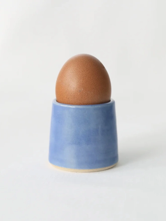 Classic Handmade Egg Cup, a ceramic egg cup sitting on a plain surface against a white backdrop. 