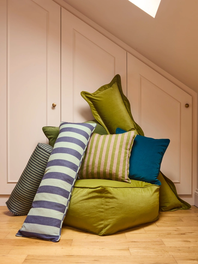 Handmade green and pink stripe linen cushions styled in bedroom cushion arrangement, Kika Bespoke