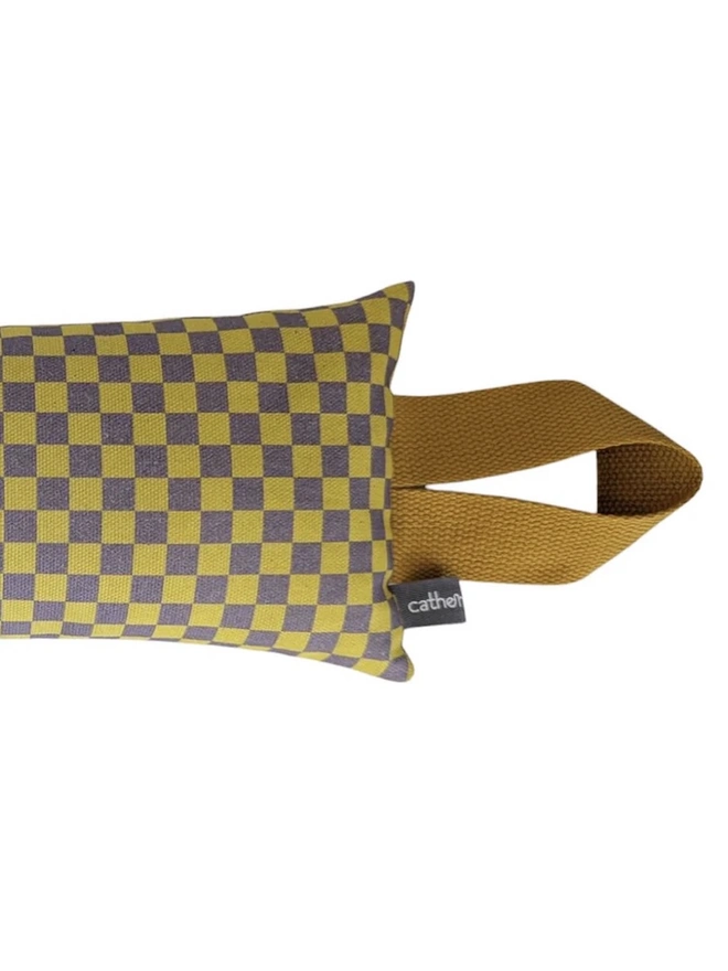 Draught Excluder, a colourful patterned draught excluder sitting on a white surface. 