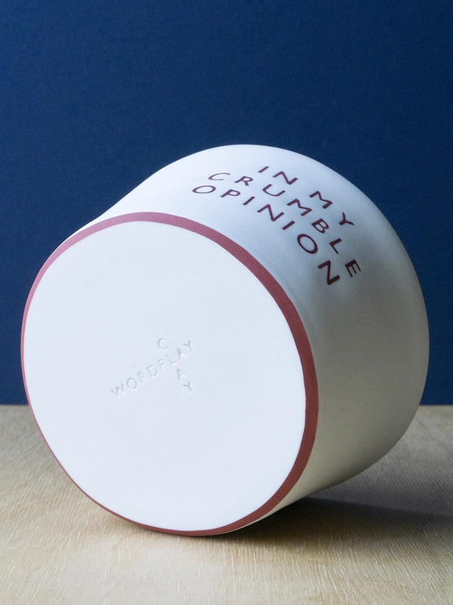 Ceramic porcelain pudding bowl with red rim and Wordplay Clay stamped into the base.