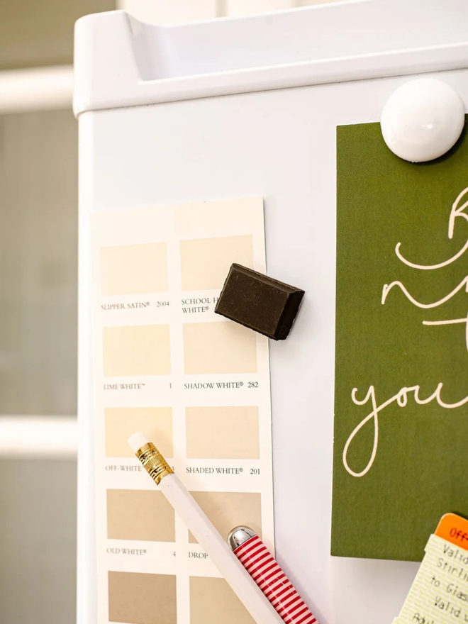 ceramic chocolate magets. a dark chocolate magnet on a fridge door.