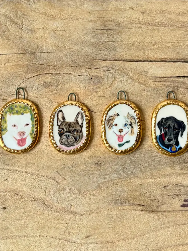 custom pet portrait pendant miniatures. four miniature painted dog portraits in pendant frames.