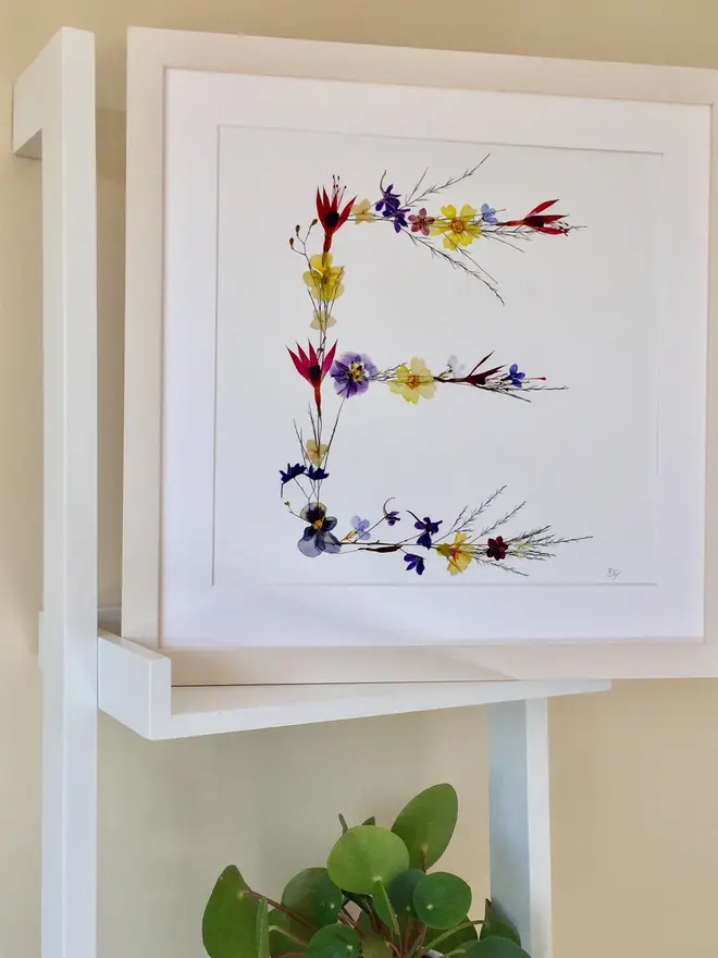 Pressed Wildflower Letter Print, a wildflower alphabet letter print sitting framed. 
