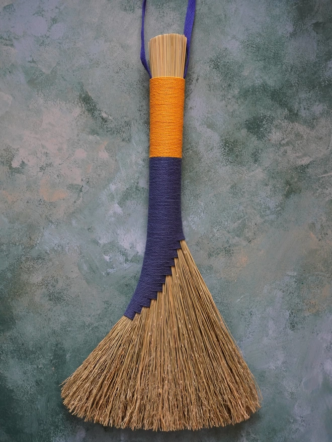 Broomcorn handbroom with blue and gold hemp cord binding