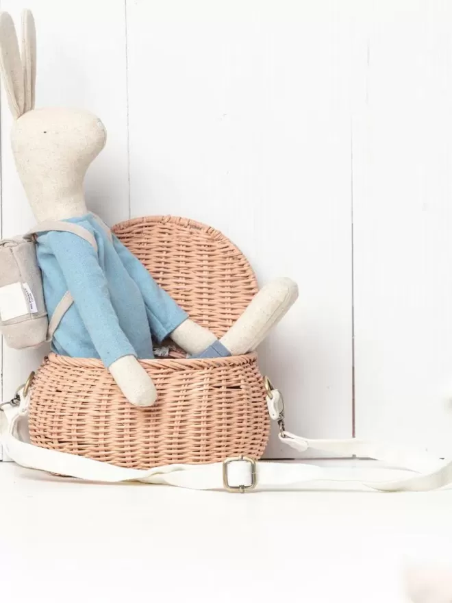 The Adventure Pickles Rabbit Wearing Blue Top and Blue Trousers Soft Toy With Grey Backpack In Basket