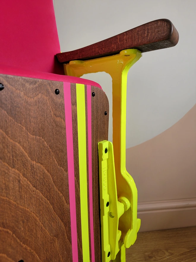 Close up of cinema seat with yellow legs and bracket