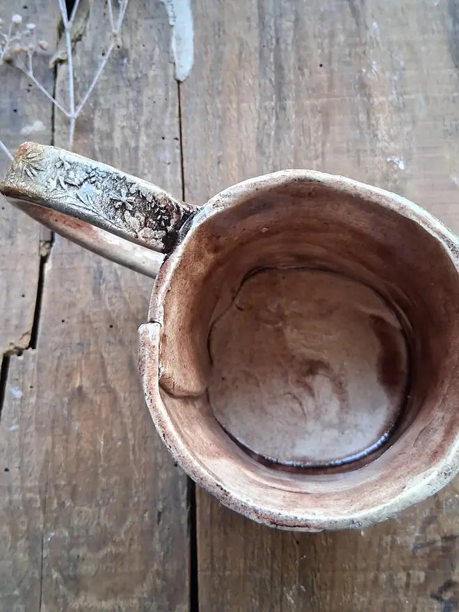 brian the snail stoneware mug. a brown mug photographed from above to show the inside.