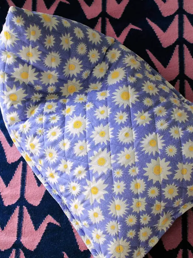 Crane Flatweave Rug, a colourful rug sitting in a living room. It is accompanied by other colourful items. 