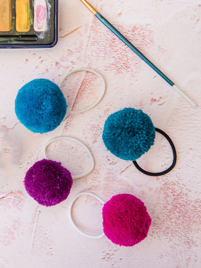 pom pom hair ties (set of four). four pom pom hair ties in regal colours.