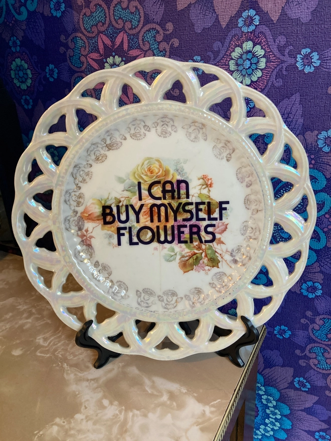 Floral vintage plate with the words 'I Can Buy Myself Flowers' printed over the top of the flowers.