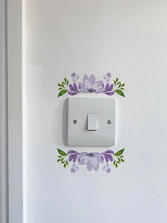 Light switch floral wall sticker, flower detail above and below light switch, handpaitnted floral design in shades of purple