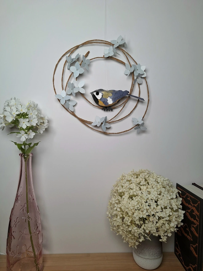 Great tit bird sculpture on a wreath of ice blue hydrangea flowers