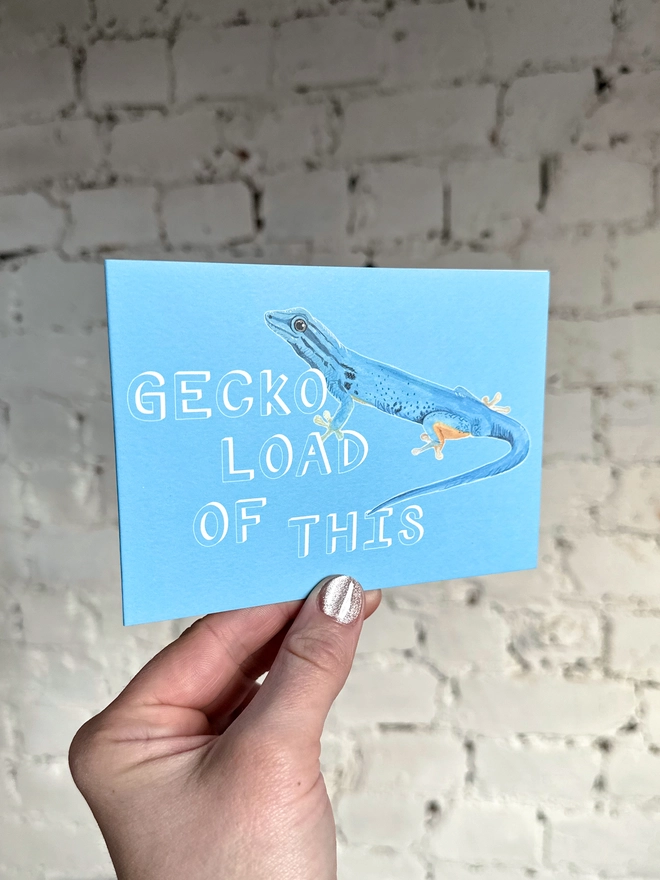 a bright blue greetings card featuring an illustration of a blue gecko with the text “GECKO LOAD OF THIS”