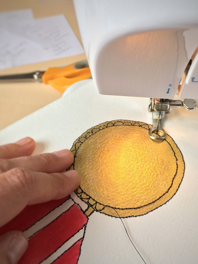 A hand made gold medal artwork being sewn by hand using freehand machine embroidery