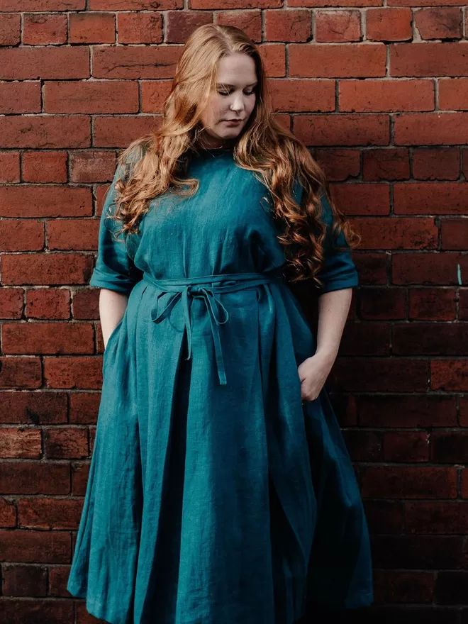 Pleated linen dress in teal front view