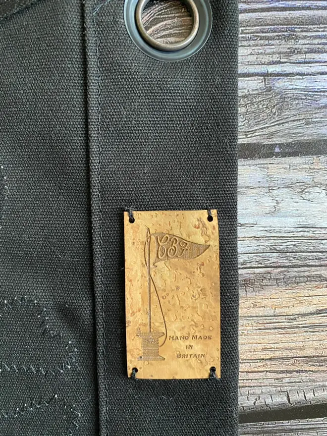 a close up of a section of a black amazons flag. you can see the eyelet and cork label