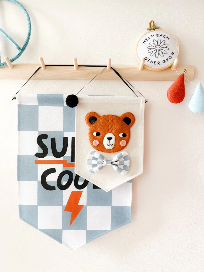 Brown bear hand sewn felt banner hanging from a wooden peg rail