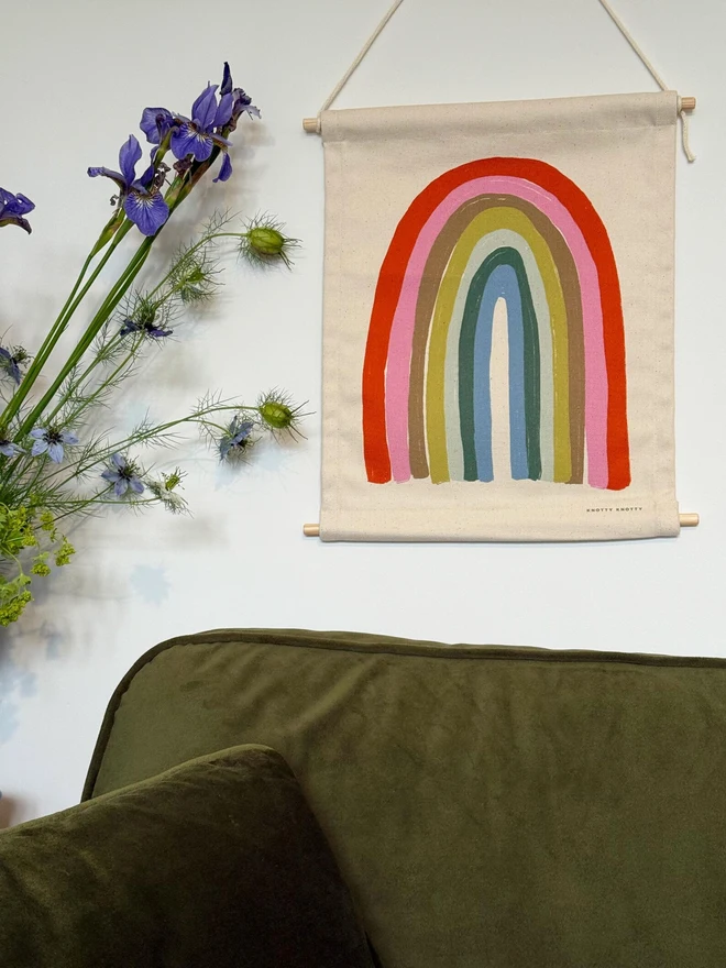Cotton Pastel Rainbow Fabric Banner, against a white wall. 