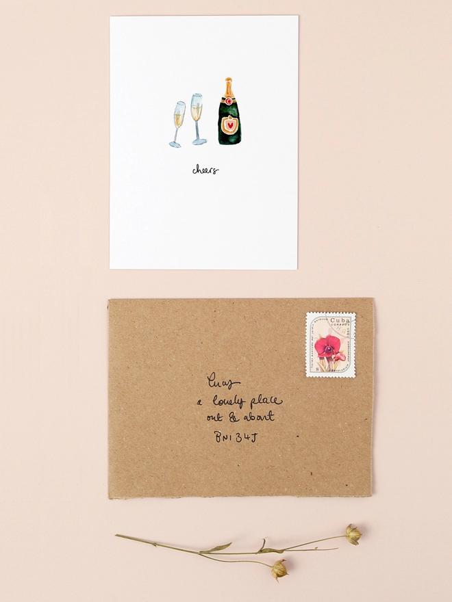 A festive illustration featuring two champagne flutes clinking together in a celebratory toast, with a bottle of bubbly. The card's compact size and elegant details make it perfect for sending congratulations or best wishes for any special occasion.