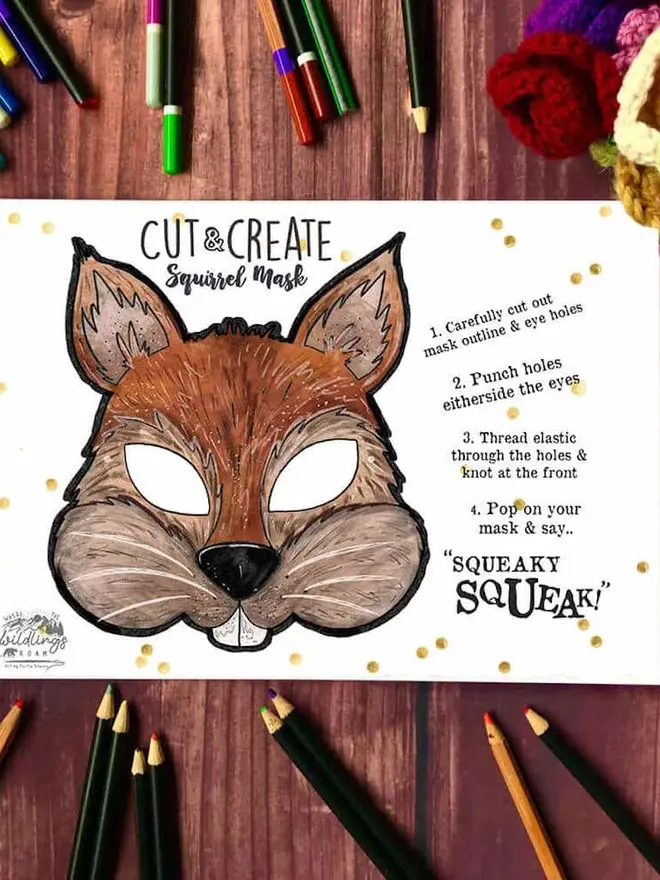 Cut And Create Forest Animals Children’s Masks Kit, an illustrated rabbit face, surrounded by coloured pencils on a dark wood background.