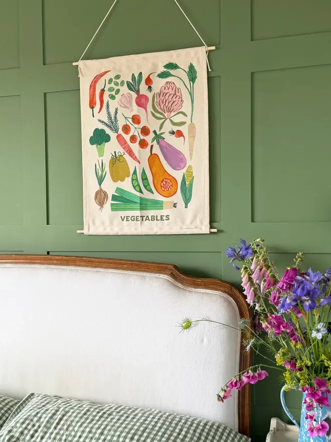 Vegetable Print Fabric Banner, against a green wall. 