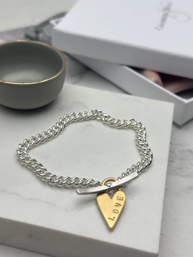 sterling silver chunky curb bracelet with silver t bar fastener and personalised gold chunky heart padlock charm. with gift box and pouch