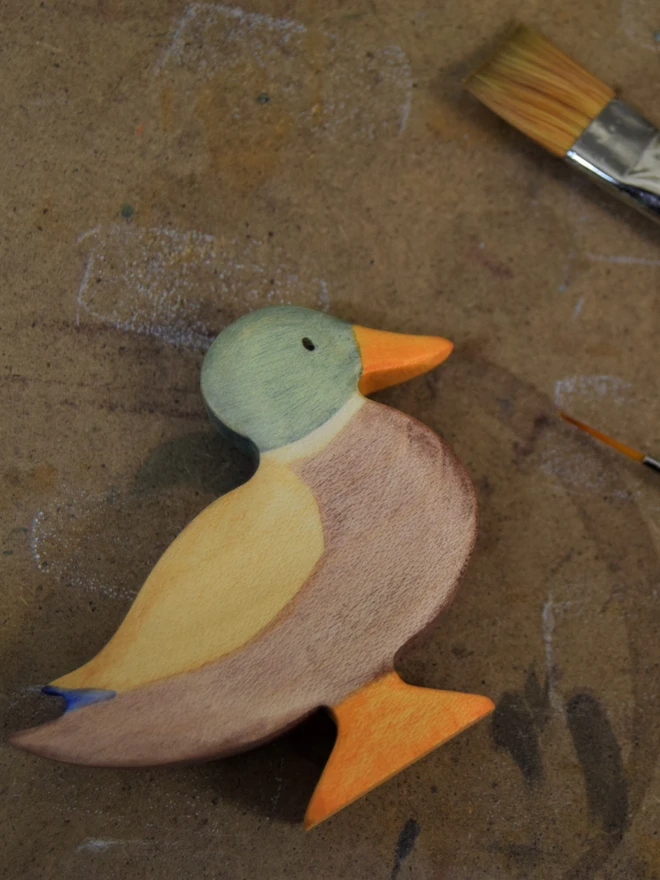 wooden toy duck on painting board