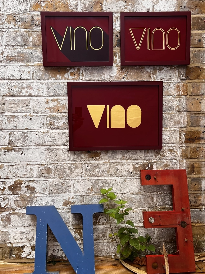 'Vino' Wine Serie Gold Leaf Glass Artwork, hanging in an exposed brick wall. 
