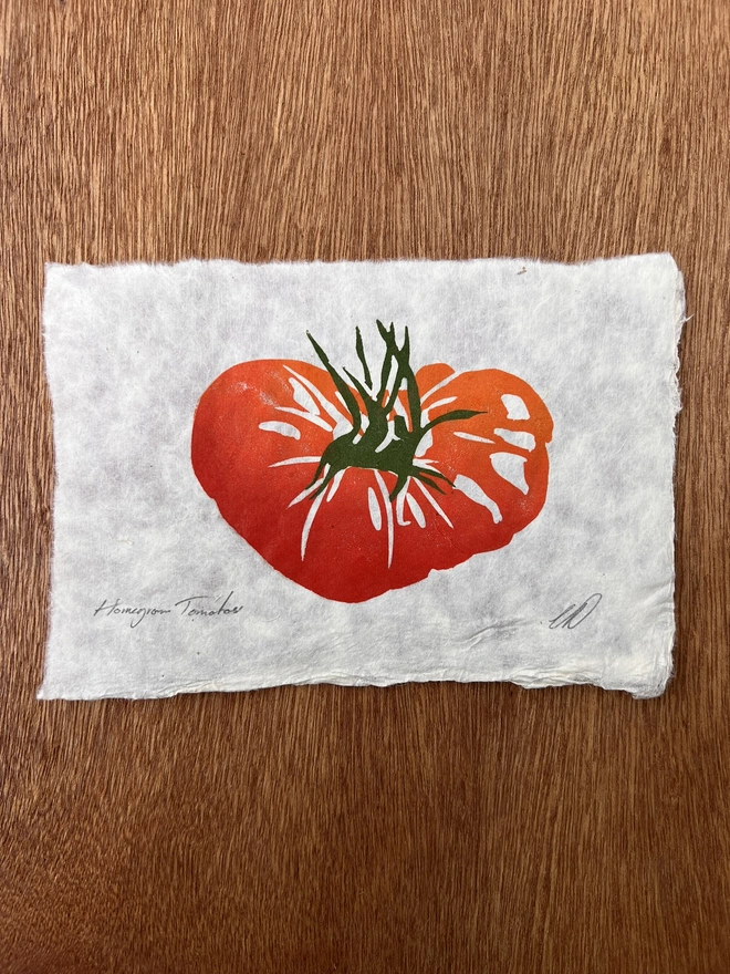 Hand-printed tomato lino print on natural handmade paper, featuring a bold graphic illustration of a ripe tomato.