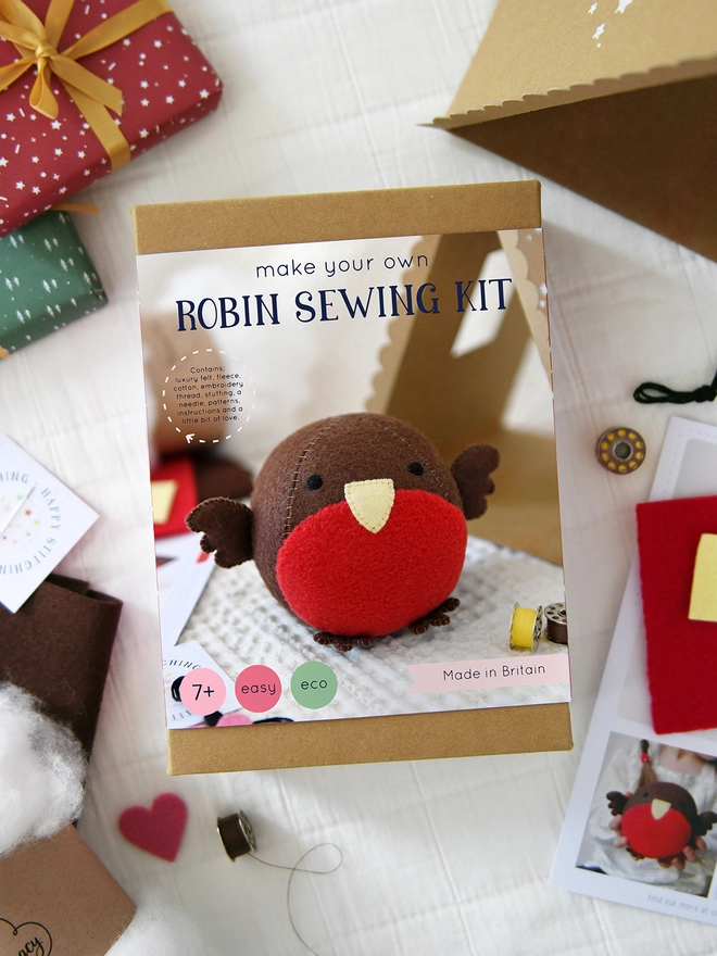 A craft kit box with an image of a robin toy on the front and the words "Make your own robin sewing kit". Craft kit components lay around the box.