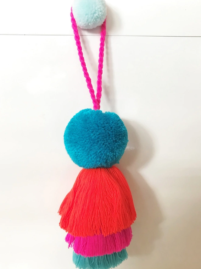 pom pom and tassel swag hanging decoration. a hanging decoration with a turquoise pom pom.
