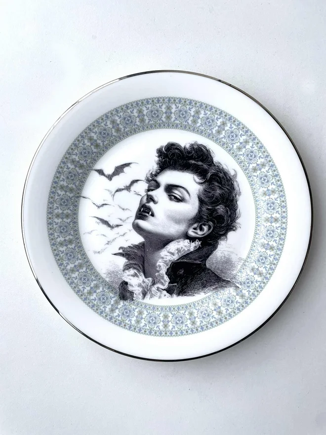 the vampire Louis wtih bats behind him, the image is victorian in black and white and is printed directly onto an ornate vintage plate
